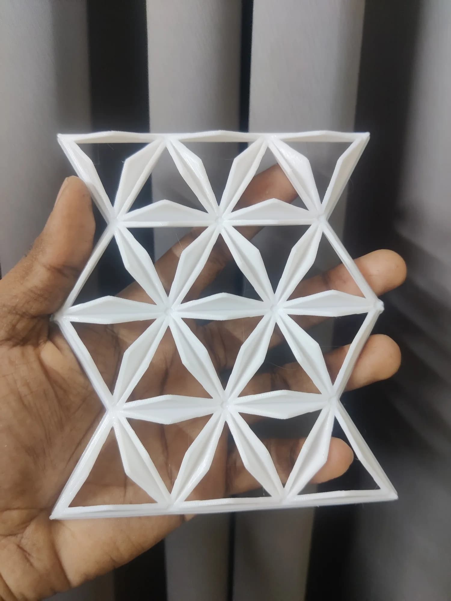 Open lattice version of the printed pattern panel, fins upright and triangular windows showing the hand behind