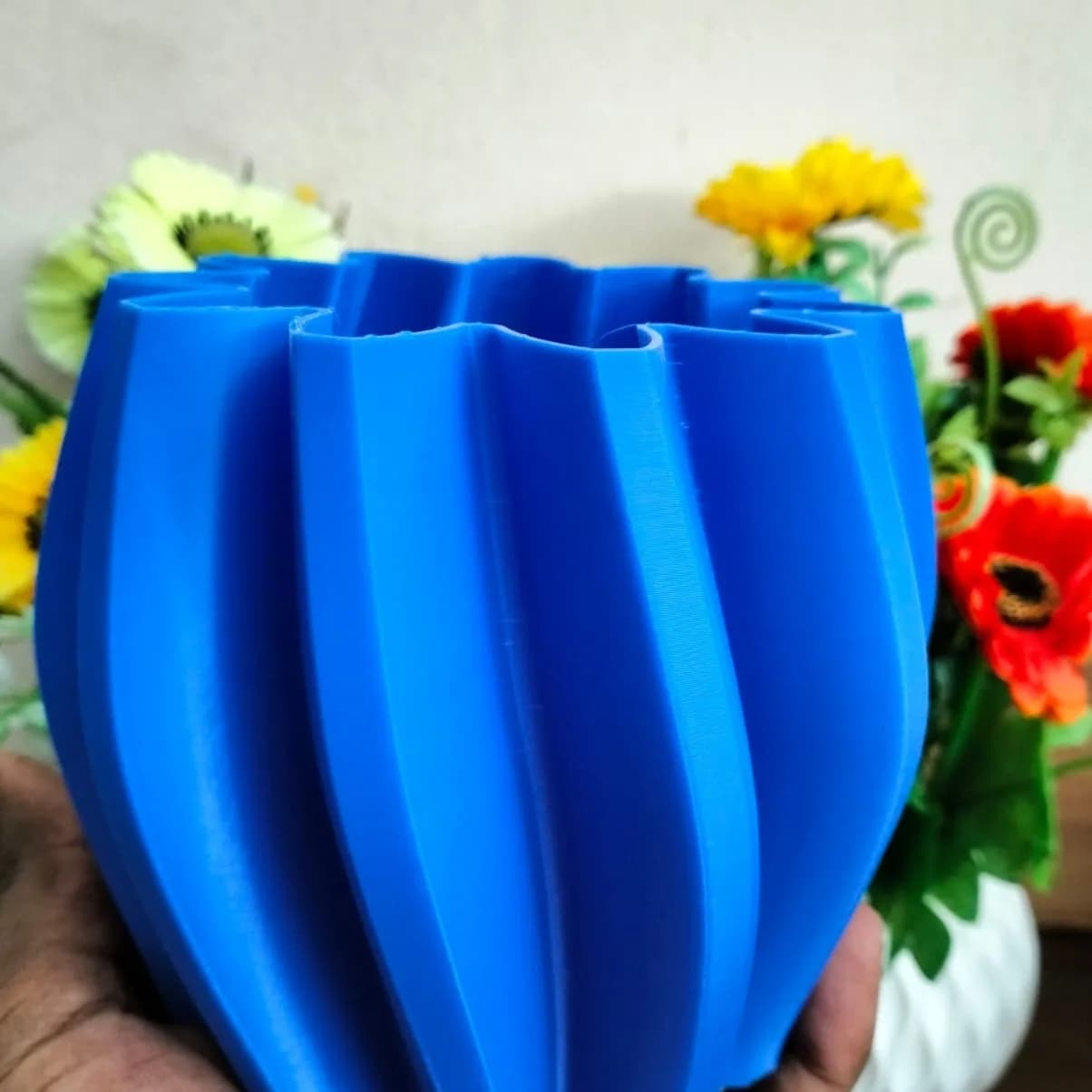 Close-up of the twisted ribs and fine, even layer lines on the blue vase