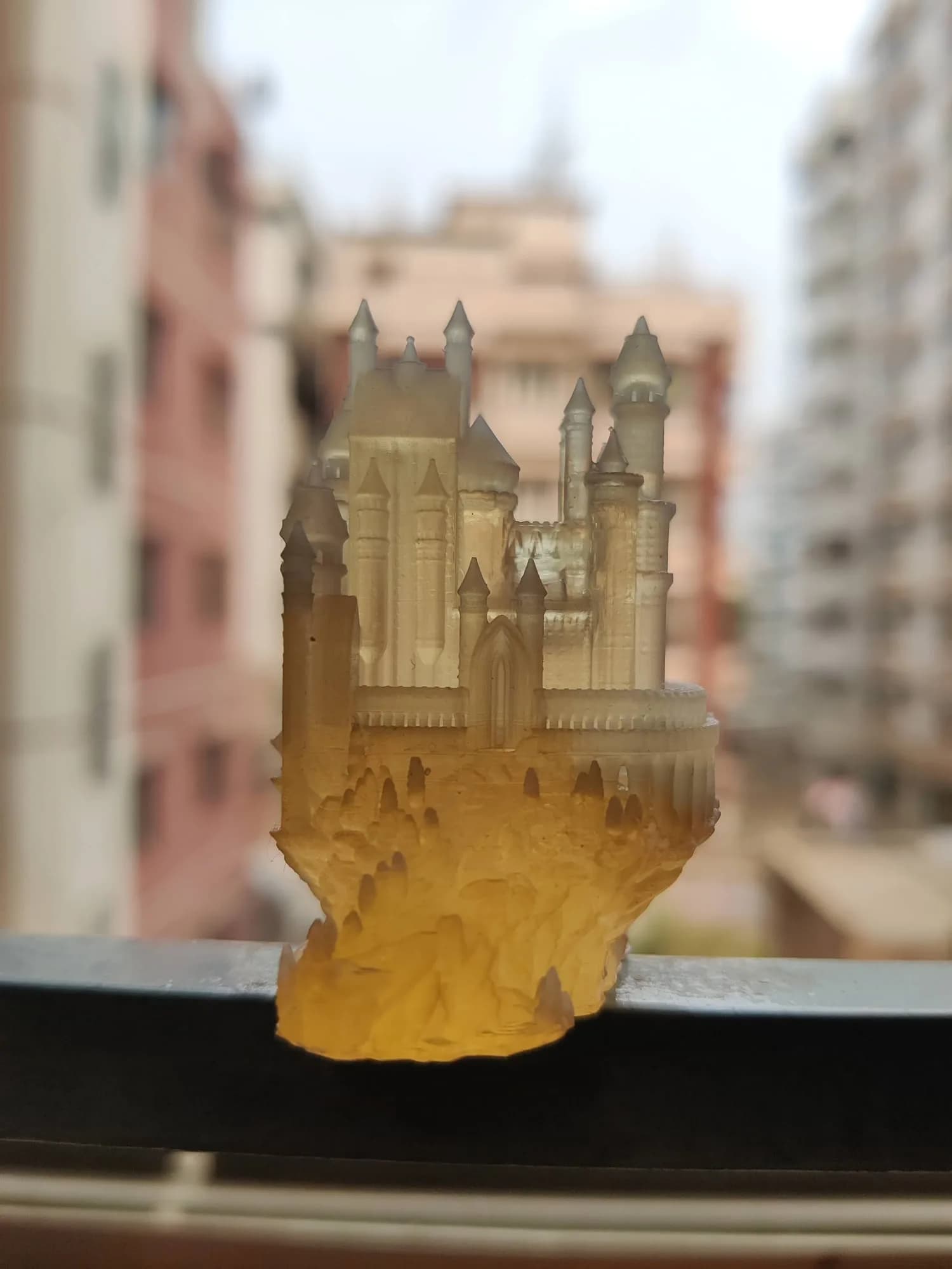 Front view of the transparent resin castle on a ledge, light passing through the towers and outer wall