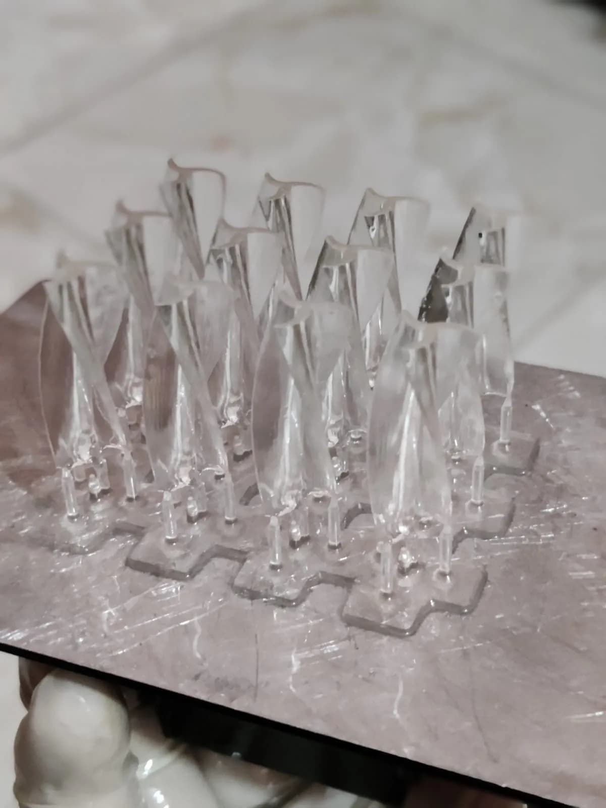 Batch of twisted clear resin spire elements on small support rafts on the build plate