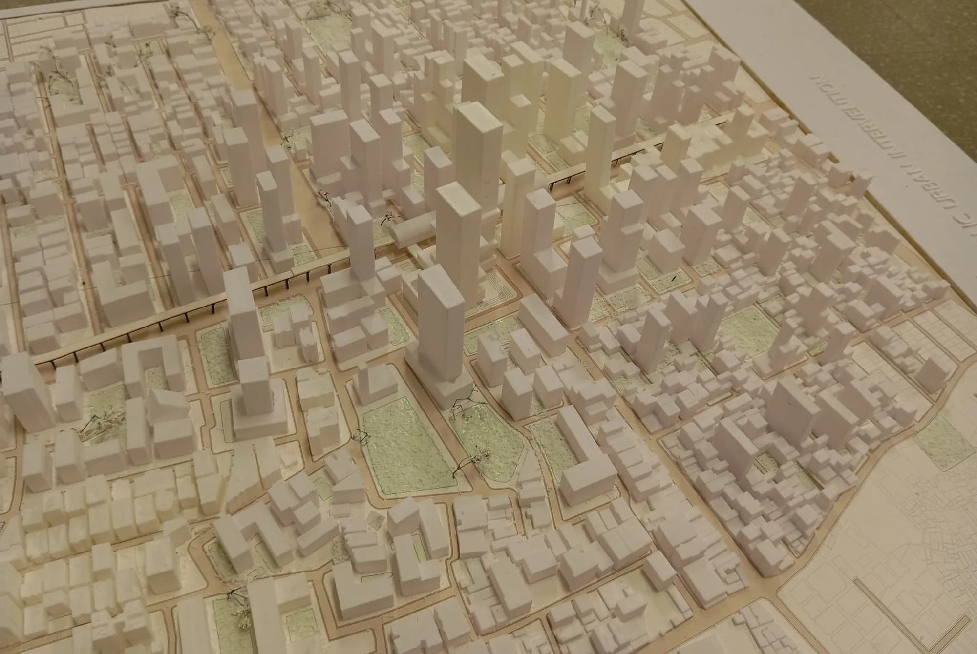 Station area of the model: proposed towers, green parks and the metro line on posts crossing the street grid