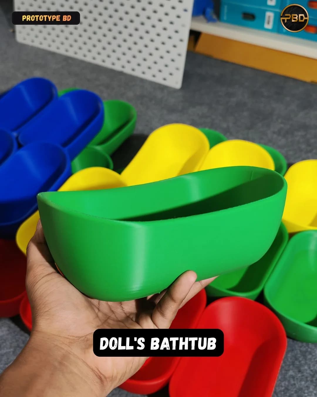 A green doll's bathtub held in a hand above the rest of the multi-colour batch