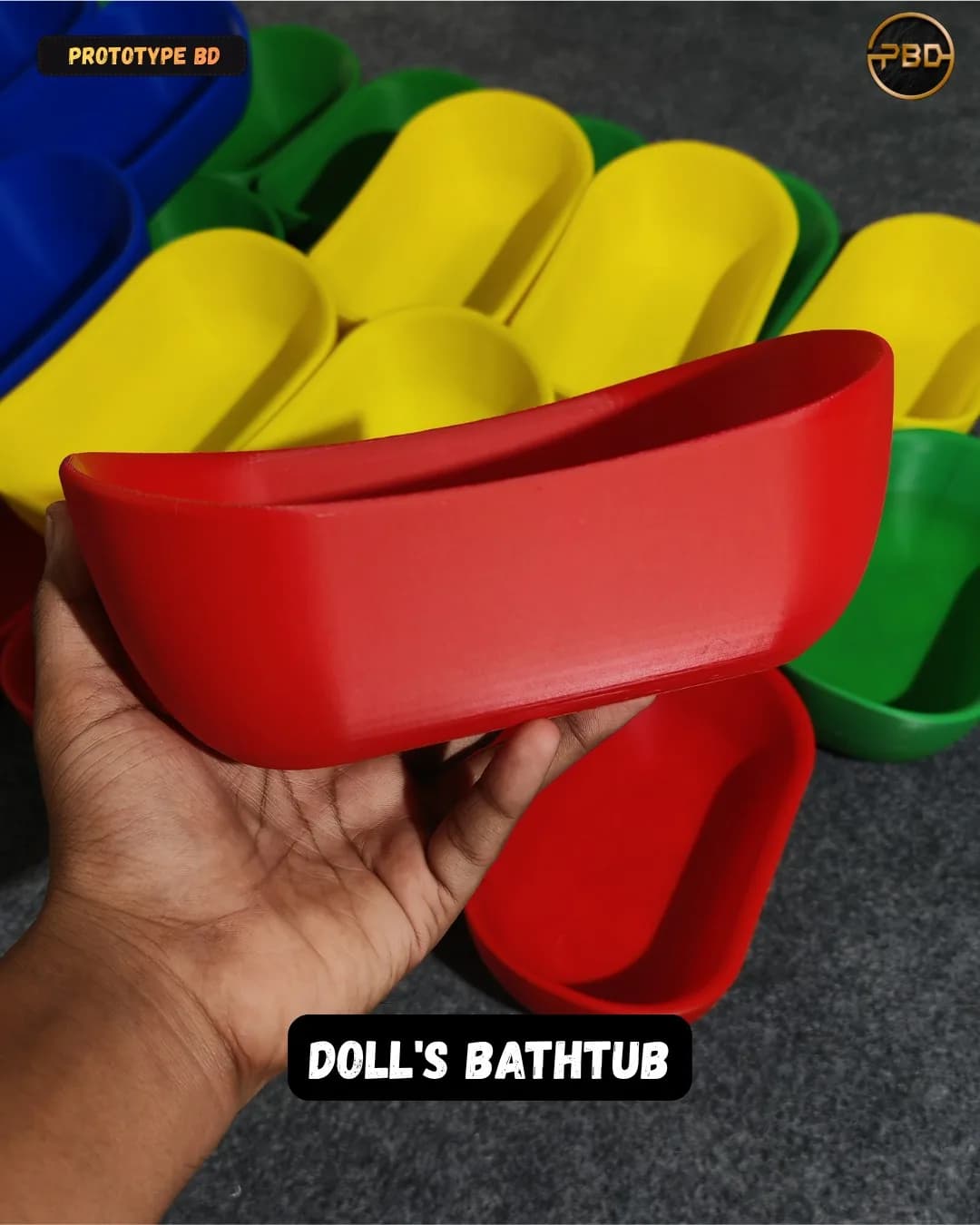 Side profile of a red doll's bathtub held in a hand, showing the raised end and thin rim