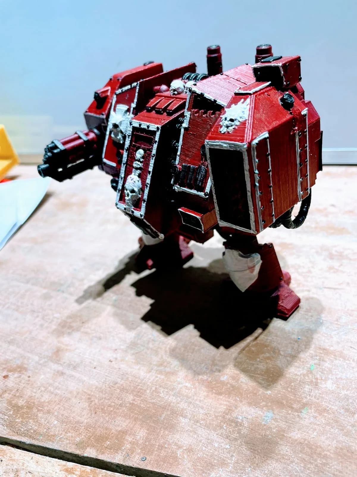 Painted Dreadnought figure in deep red with silver edging and white skull emblems, three-quarter view