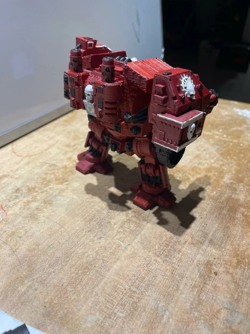 Side view of the painted Dreadnought figure showing red armour, black hoses and white emblems