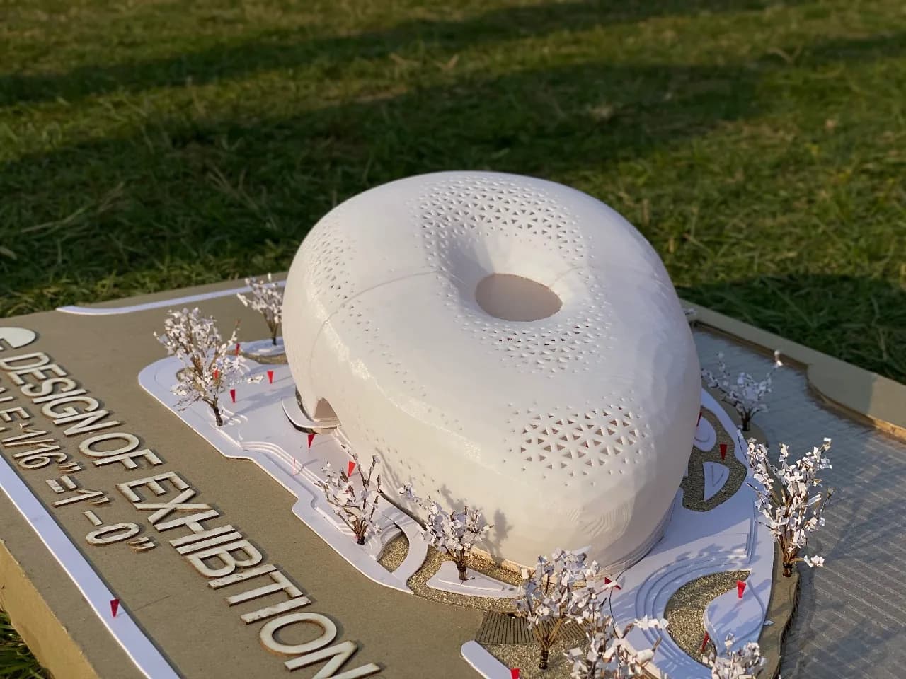 Close-up of the rounded 3D printed shell with a roof opening, beside the raised cut letters of the title