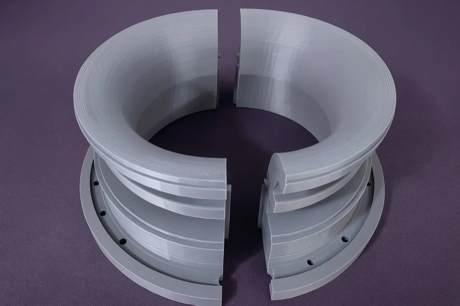 Two halves of the 3D printed funnel collar side by side, with the stepped interlocking keys visible on the split faces