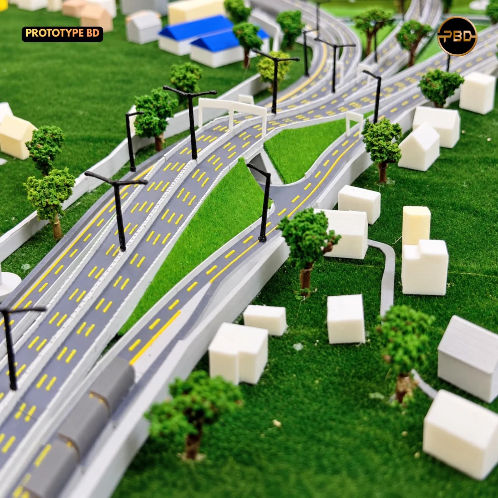 Close-up of the highway lanes with yellow markings, lamp posts, trees and housing blocks on the Hatikamrul Interchange model