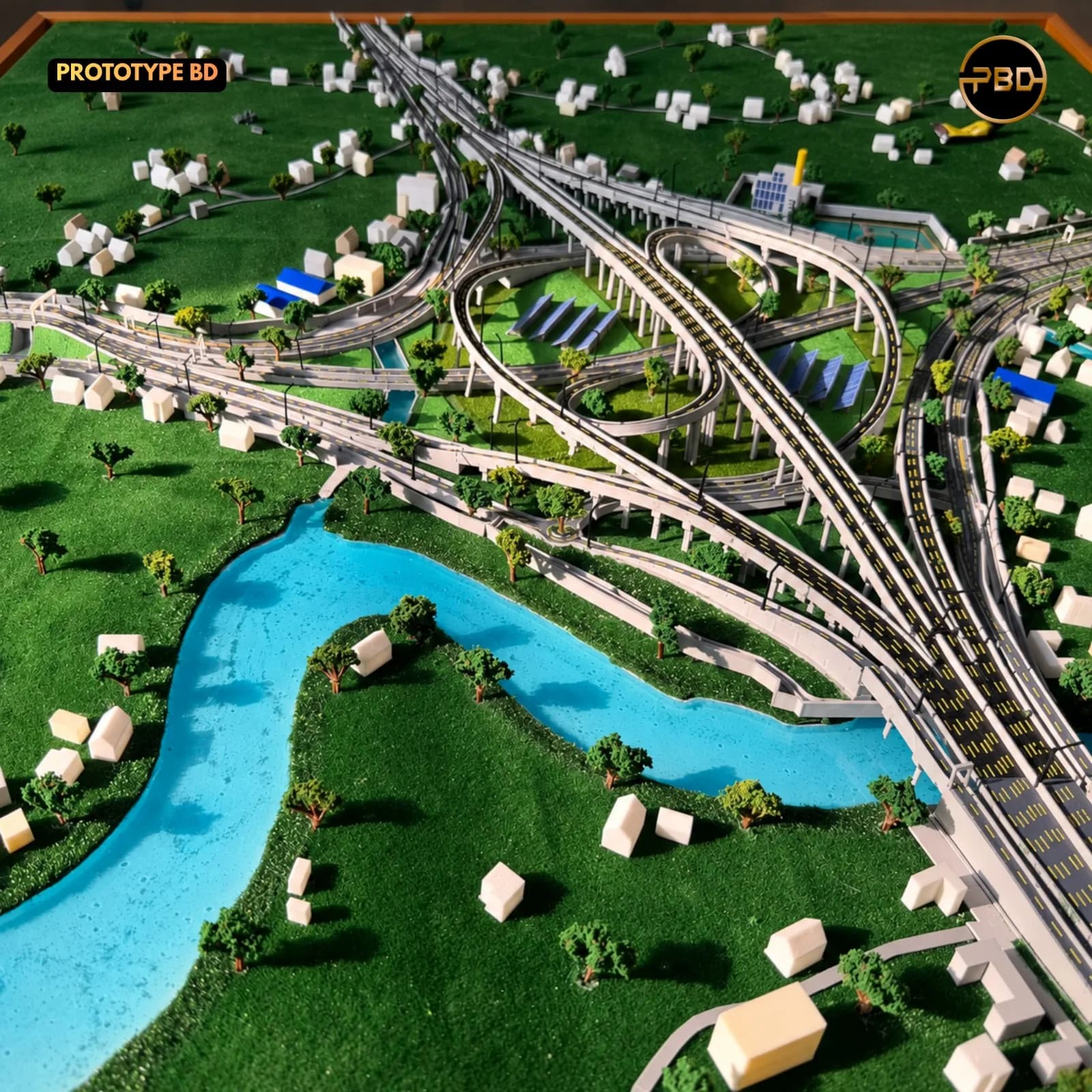 Winding river, trees and village housing blocks in the landscape of the Hatikamrul Interchange model