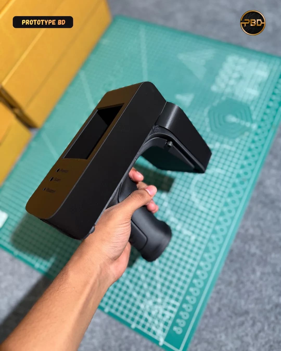 Angled view of the black device enclosure showing the display window and pistol grip