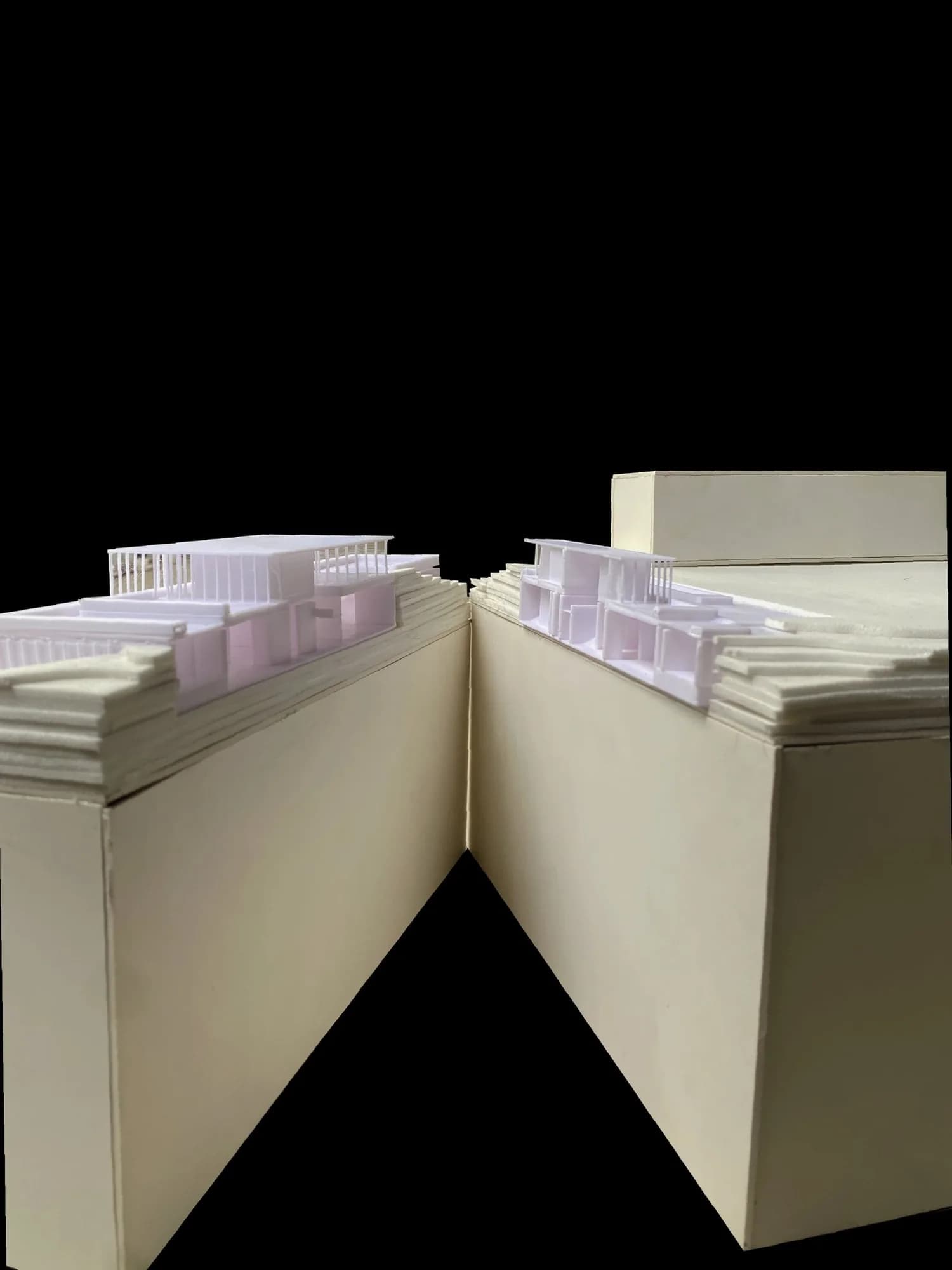The two halves of the museum model opened along the section line, showing stacked terrain layers and the building inside