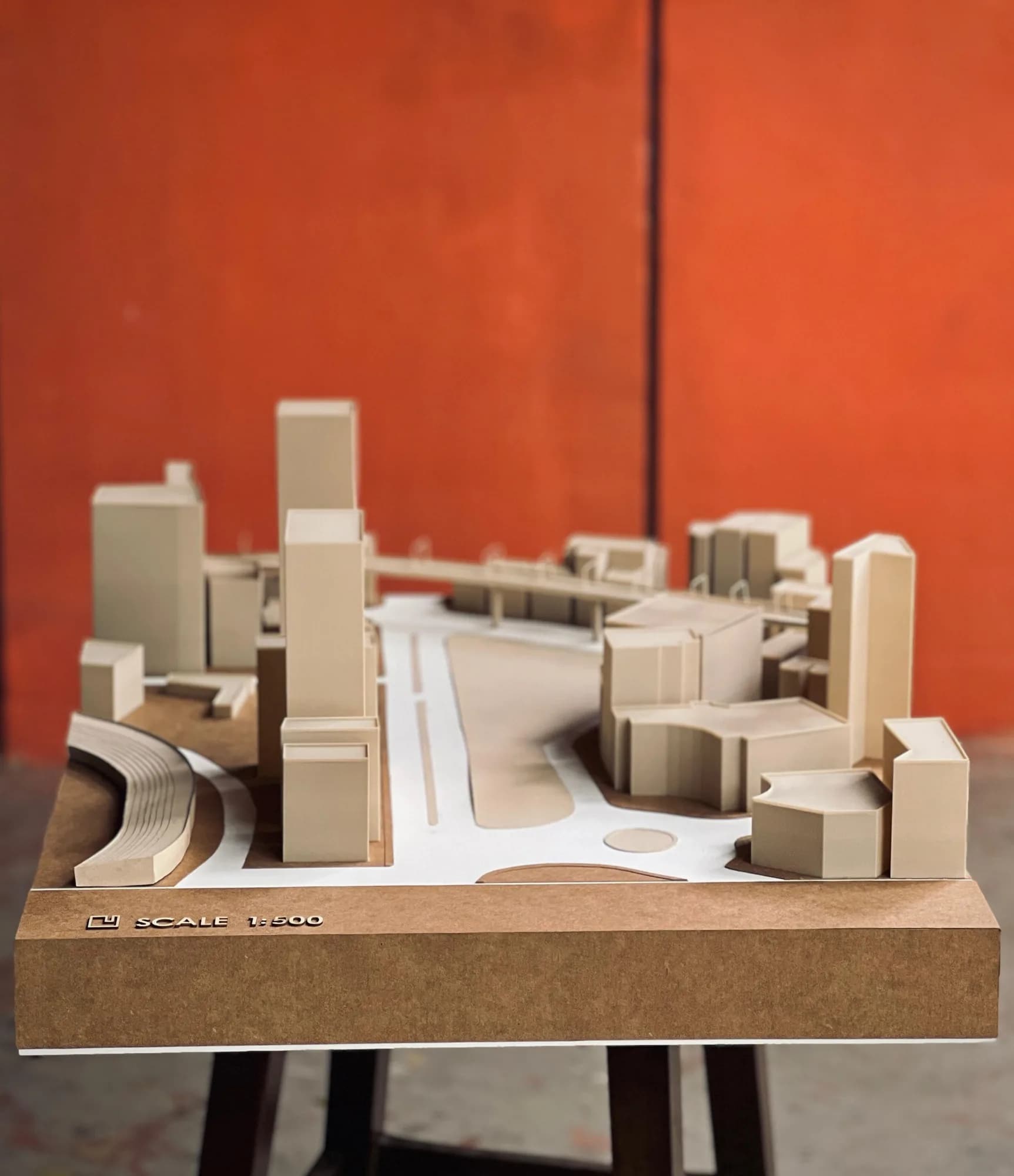 Front view of the Motijheel CBD model on a stand against a red wall, scale marking on the base