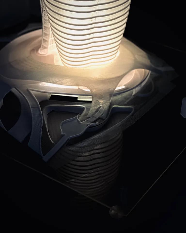 Lit podium of the tower model seen from above, with curved printed forms around the tower base