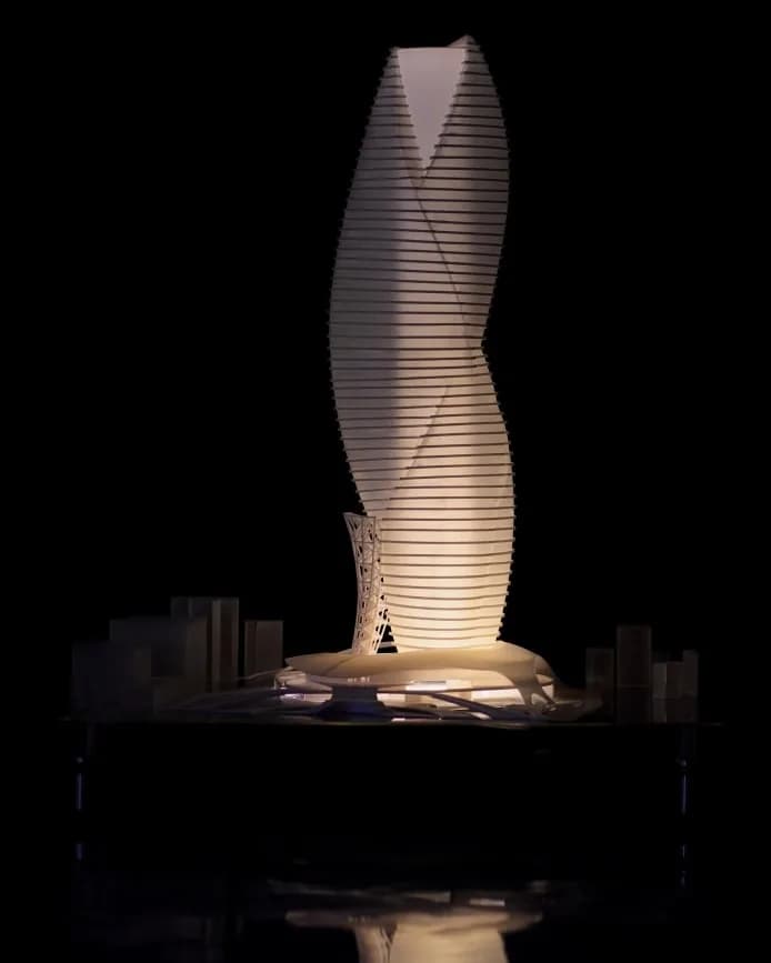 Front view of the lit high-rise model with surrounding context blocks and its reflection below