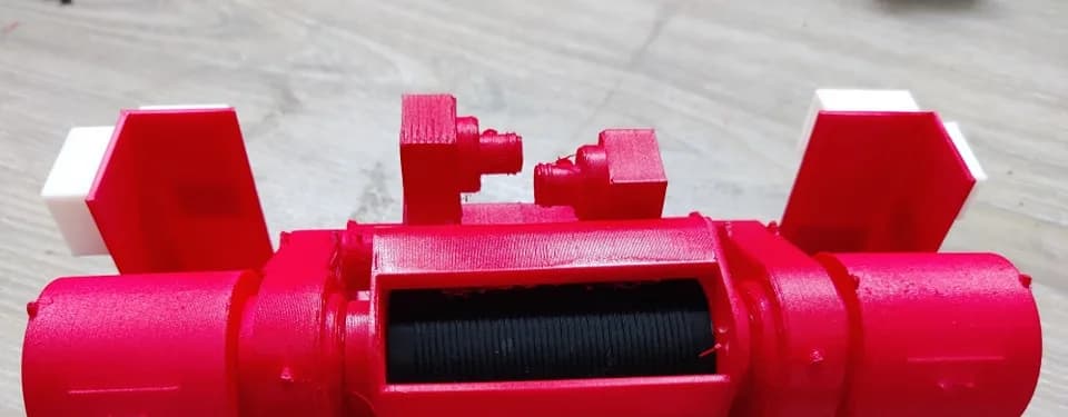 Top view of the oil-rig equipment model showing the black grooved cable drum between the red motor housings