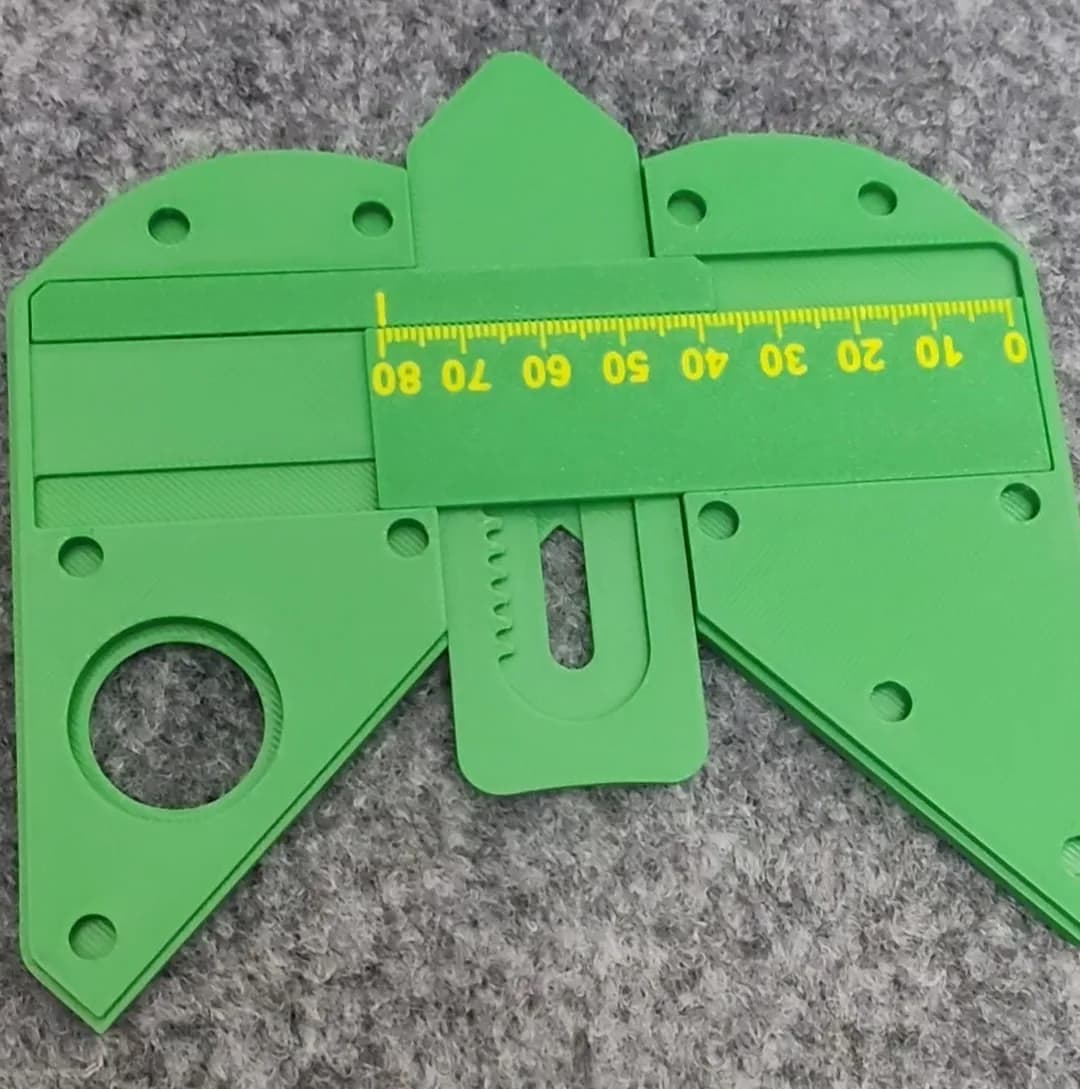 Green 3D printed radius gauge body with a yellow-marked 0 to 80 scale strip, mounting holes and a toothed slider