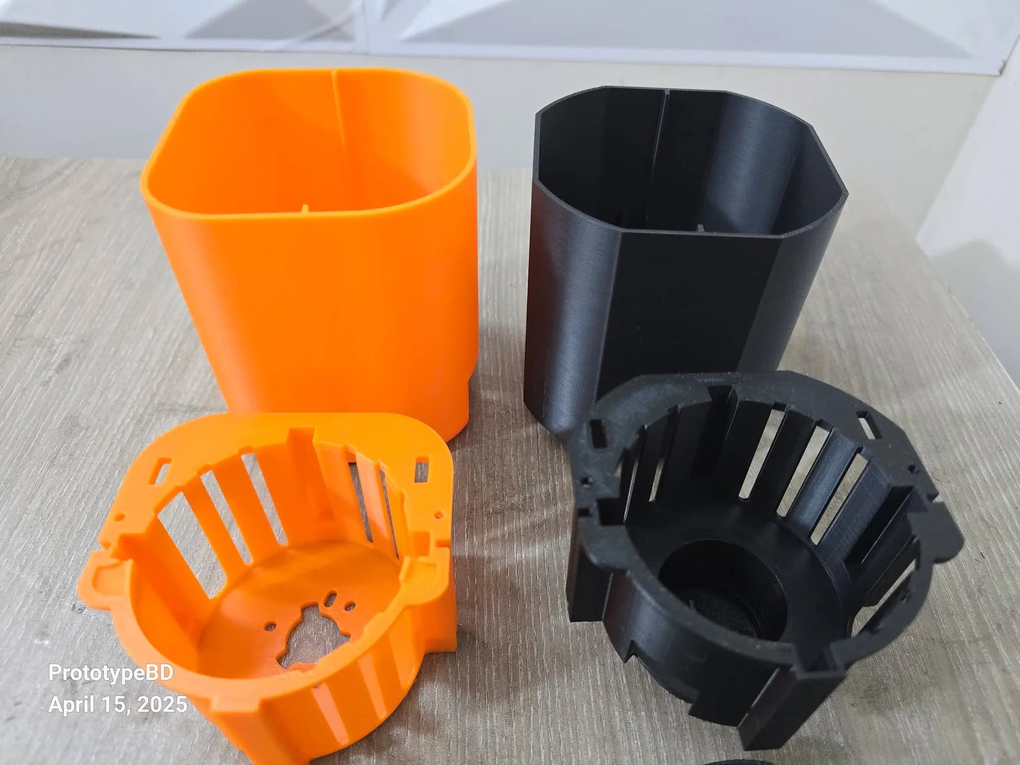 Close-up of the orange rounded-square and black octagonal fan housings with ventilated motor cages in front