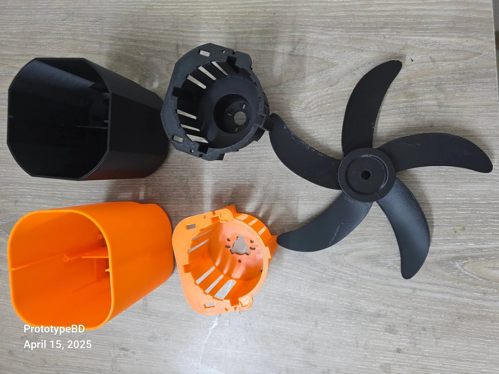 Top view of the fan prototype parts: two housings, two motor cages and the five-blade rotor