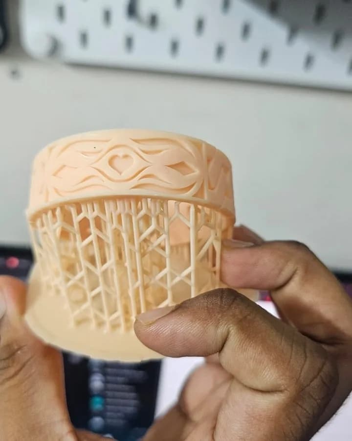 Close-up of the bangle's carved heart and wave relief while it is still on its print supports