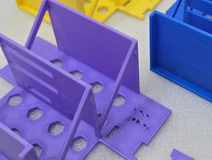 Close-up of the purple robot base plate with the designer's name embossed into the 3D printed surface