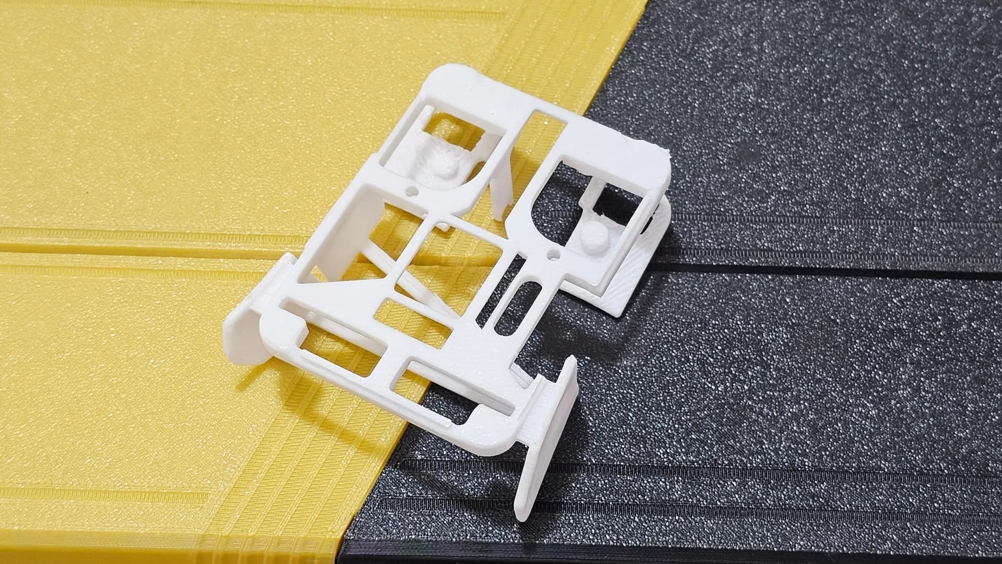 Underside of the white printed mouse shell showing the skeleton frame, mounting bosses and cut-outs