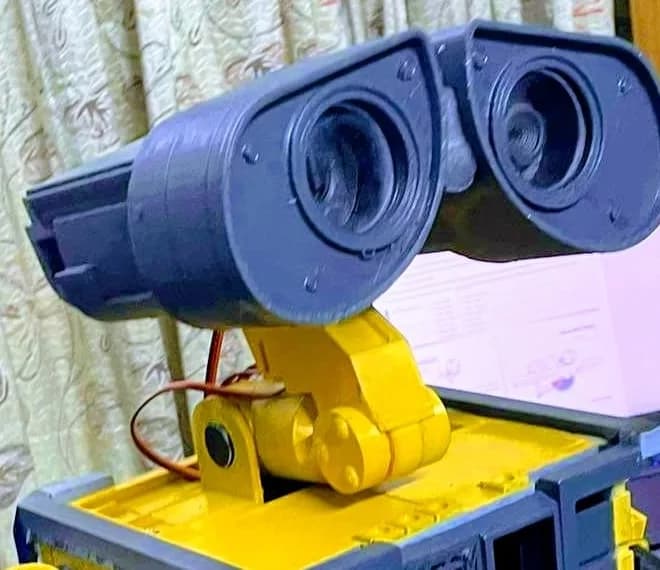 Close-up of the printed binocular eye housings and the jointed yellow neck with a servo and its wires