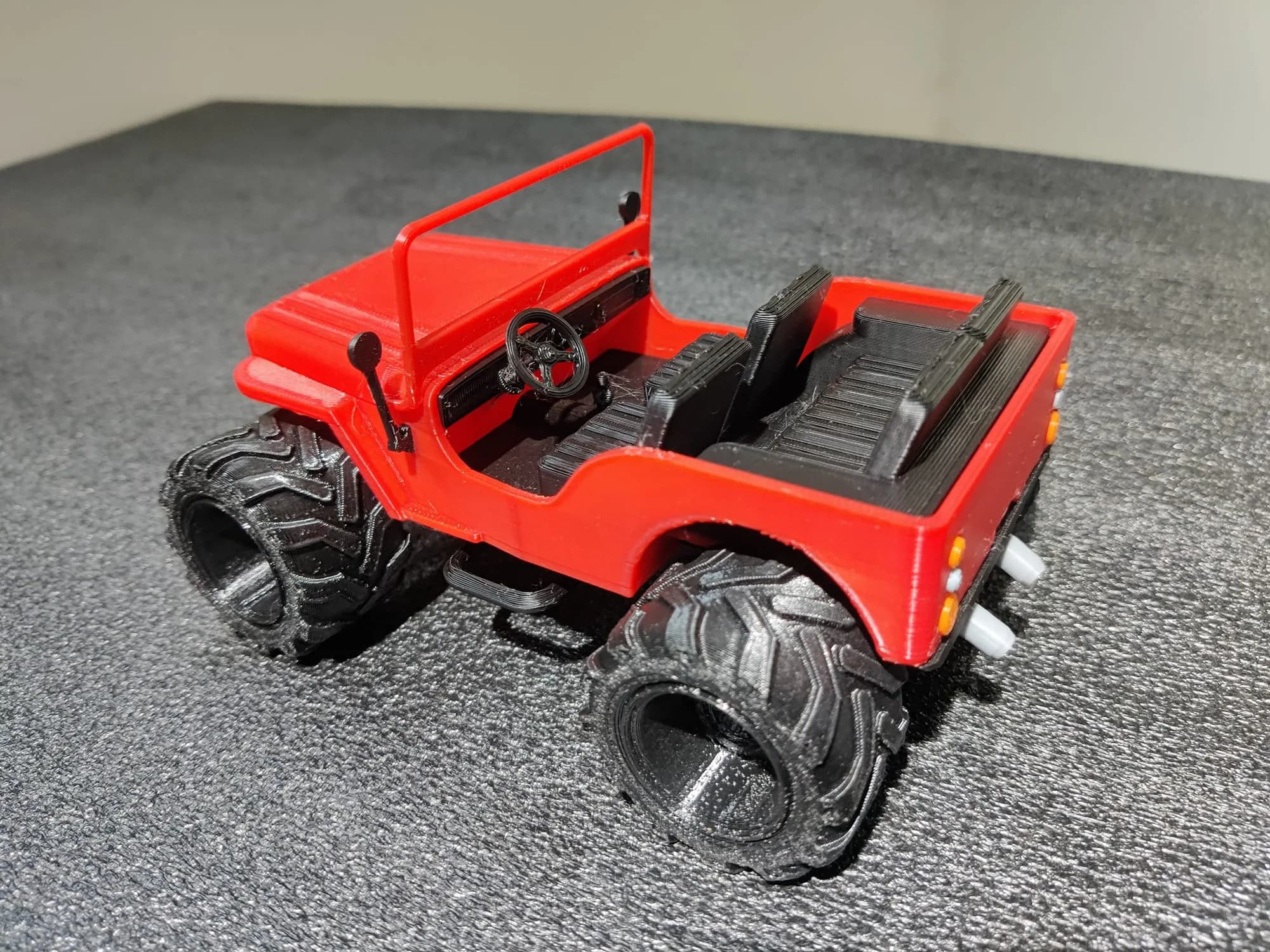 Jeep model from above showing the black dashboard, steering wheel and ribbed seats inside the red body