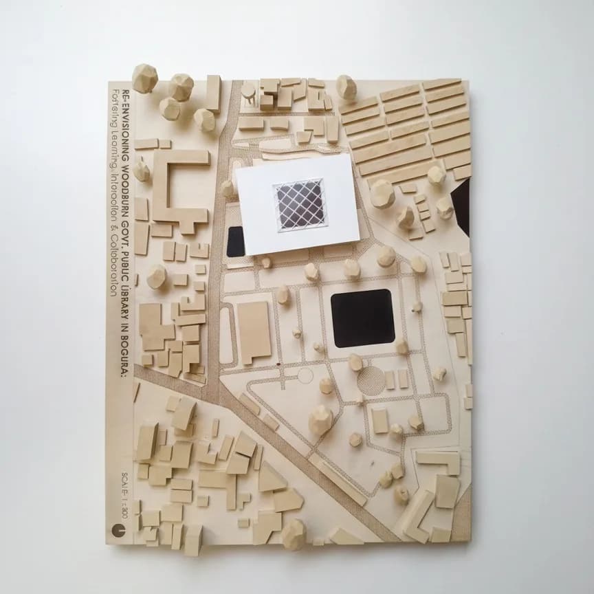 Top view of the Woodburn Public Library site model, Bogura: laser-engraved wooden site plan with roads, paths and the 1:300 scale on the edge