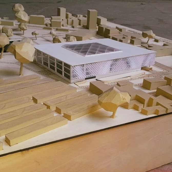 Library model seen across rows of context blocks and low-poly trees on the engraved wooden base