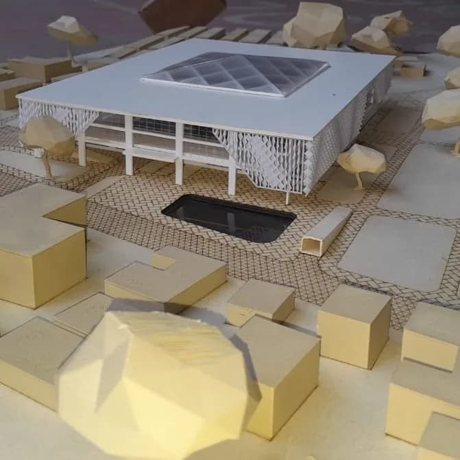 White library building on an engraved plaza, with 3D printed low-poly trees and context blocks in front