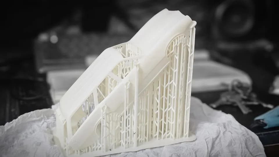 Resin car body still on its tilted lattice of thin print supports after coming off the printer