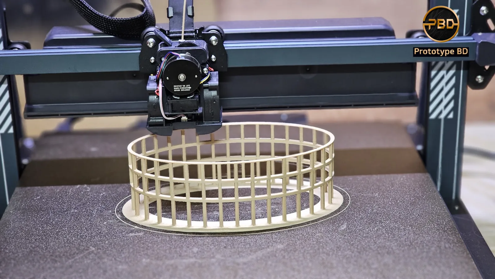 Circular colonnade model in wood-textured filament on an FDM printer: thin columns joined by two horizontal rings