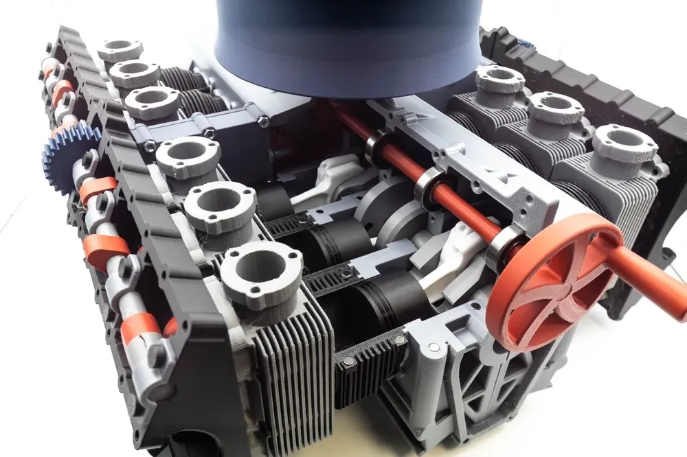 Half-scale 3D printed flat-12 engine model with finned cylinders, top fan housing and a red hand crank