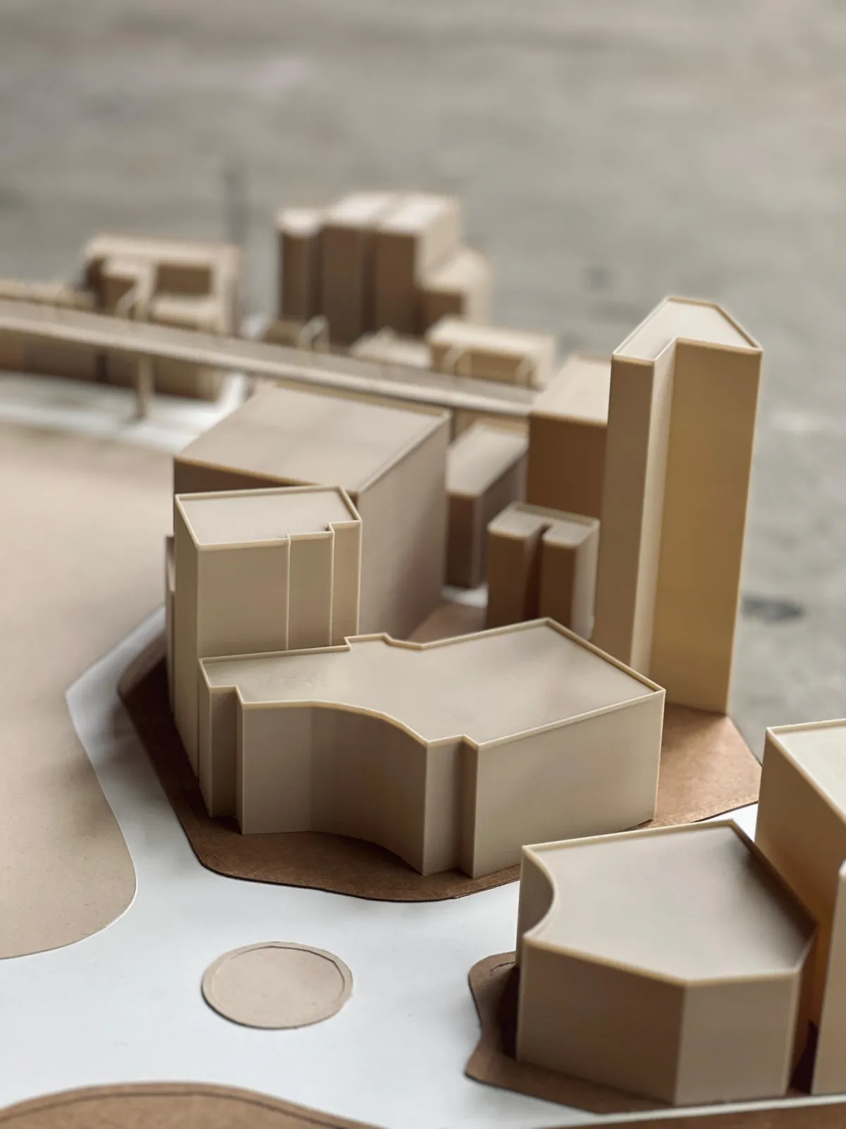 Close-up of beige 3D-printed mass blocks of a city-centre site model, with a raised walkway behind them