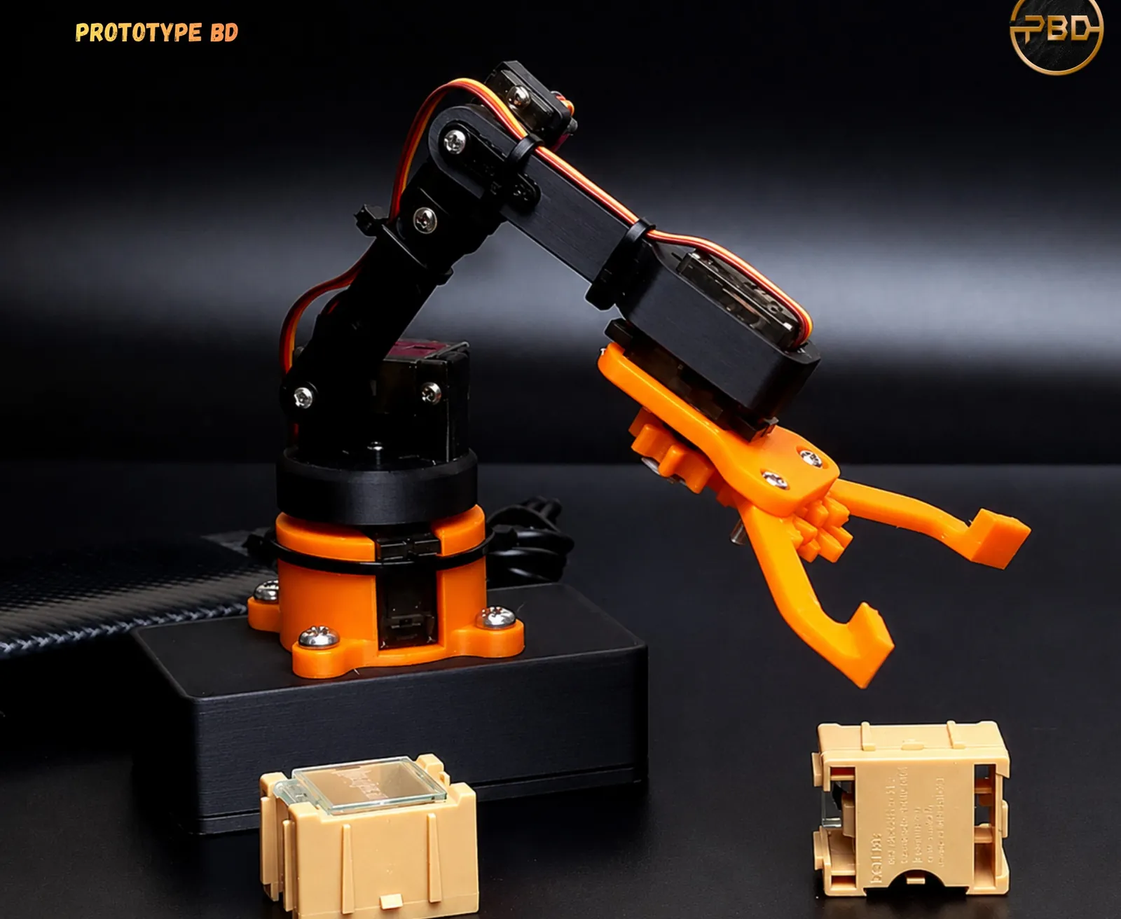Small assembled robotic arm with black links, an orange base and an orange gripper, driven by hobby servos