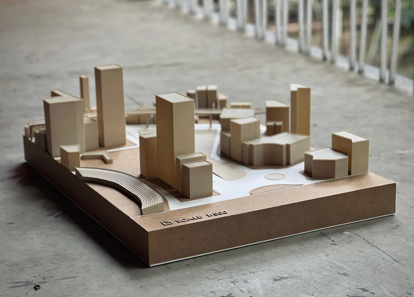 Beige 3D-printed building blocks, a curved ribbed structure and a raised walkway on a brown base marked scale 1:500