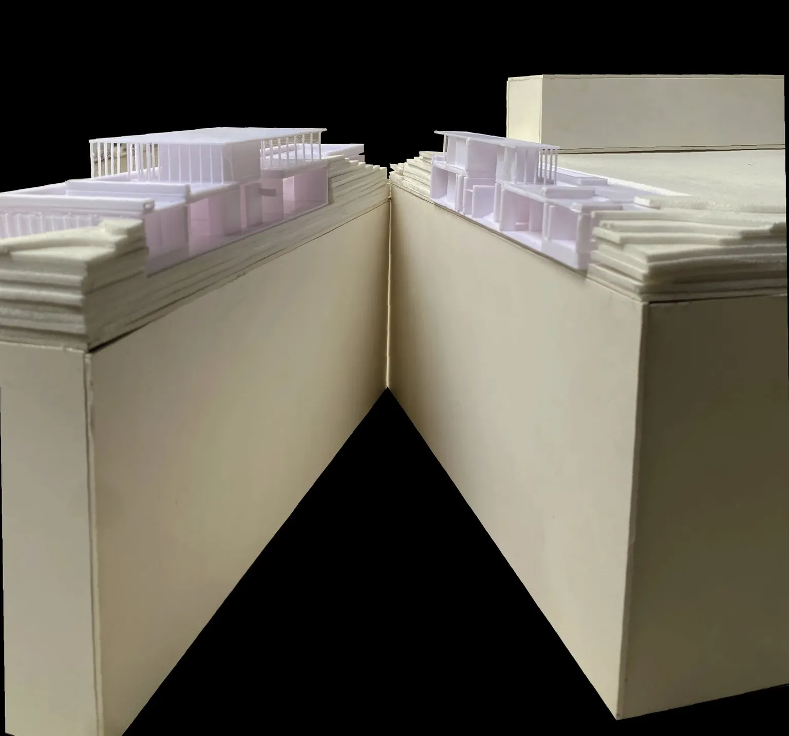 Study model opened into two halves along a section line, with white printed building parts set in stepped terrain